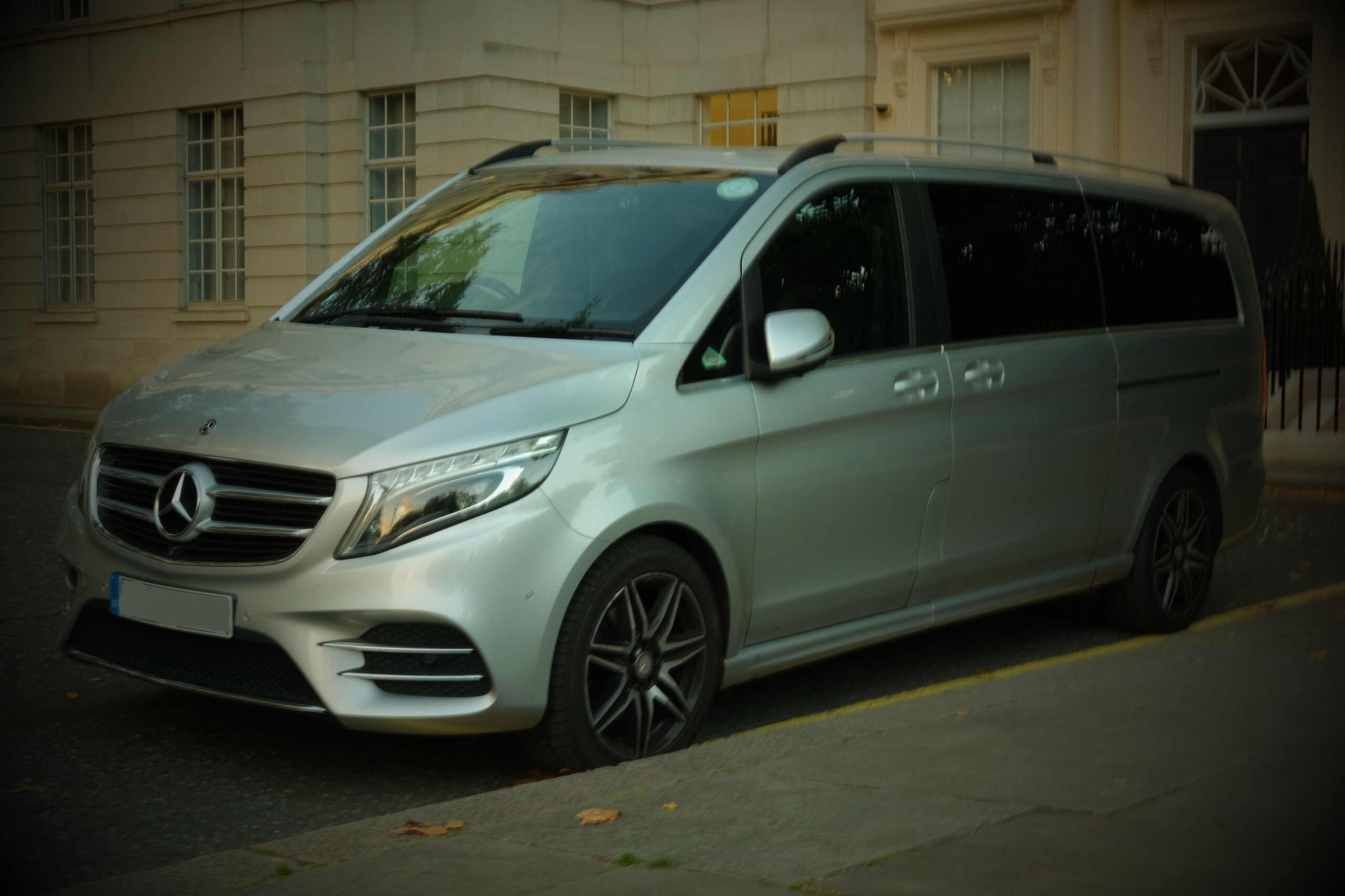 Silver Mercedes V-Class people carrier parked beside a building in London